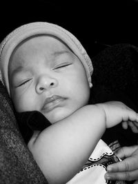 Close-up of cute baby boy sleeping in darkroom