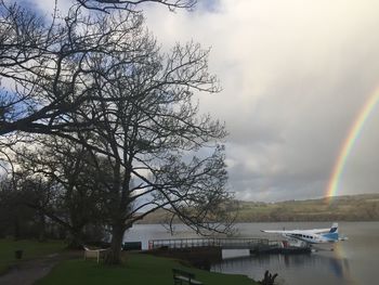 Scenic view of rainbow over river against sky