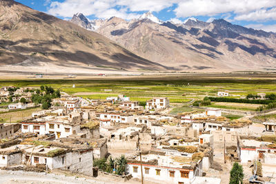 Scenic view of townscape and mountains against sky