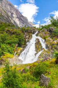 Scenic view of waterfall against sky