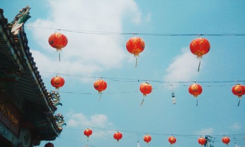 Low angle view of lanterns hanging against sky