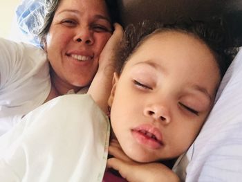 Portrait of mother and baby on bed