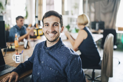 Portrait of a smiling young man sitting at table