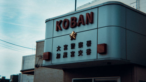 Low angle view of text on building against sky