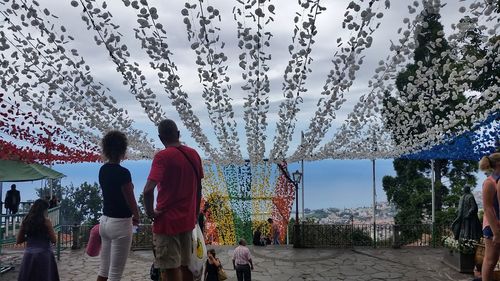 Rear view of people in water against sky