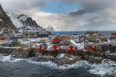 Buildings by sea against sky