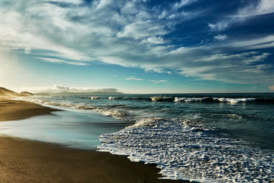 Scenic view of beach against sky during sunrise