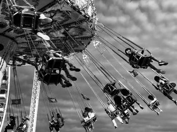 Low angle view of chain swing ride against sky