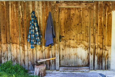 Two wooden axes stuck in the wood chopping trunk. in the background, a wooden wall of the old house.