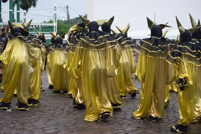 Group of people in costumes play fun games during the carnival 