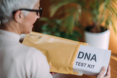 Senior woman doing a mailed dna test at home