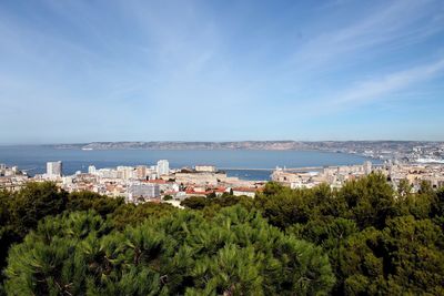 Scenic view of sea and cityscape against sky