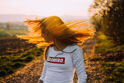 Rear view of woman standing on field