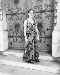 Portrait of woman standing against wall