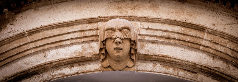 Low angle view of statue against old building