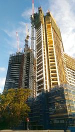 Low angle view of modern building against cloudy sky