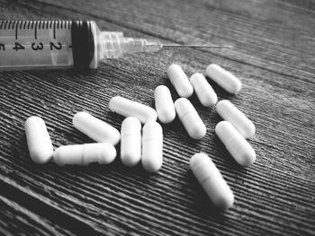 High angle view of syringe with medicines on table