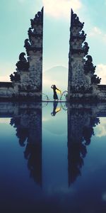 Reflection of silhouette man in water against sky