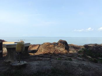 Rocks by sea against sky