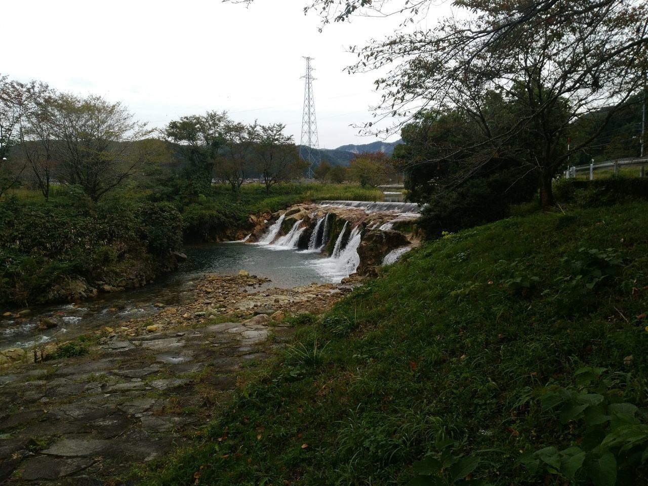 SCENIC VIEW OF WATERFALL AGAINST SKY