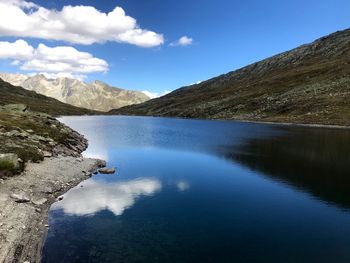 Scenic view of lake and mountains against blue sky