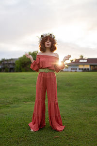 Full length of smiling girl standing on field
