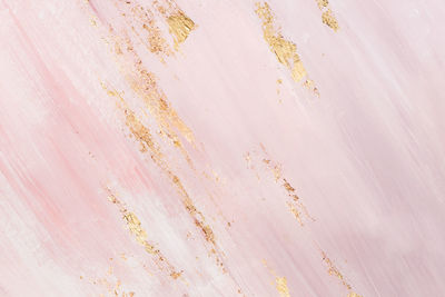Delicate pink marble background with gold brushstrokes. place for your design.