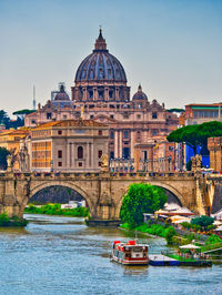 Bridge over river against buildings in city