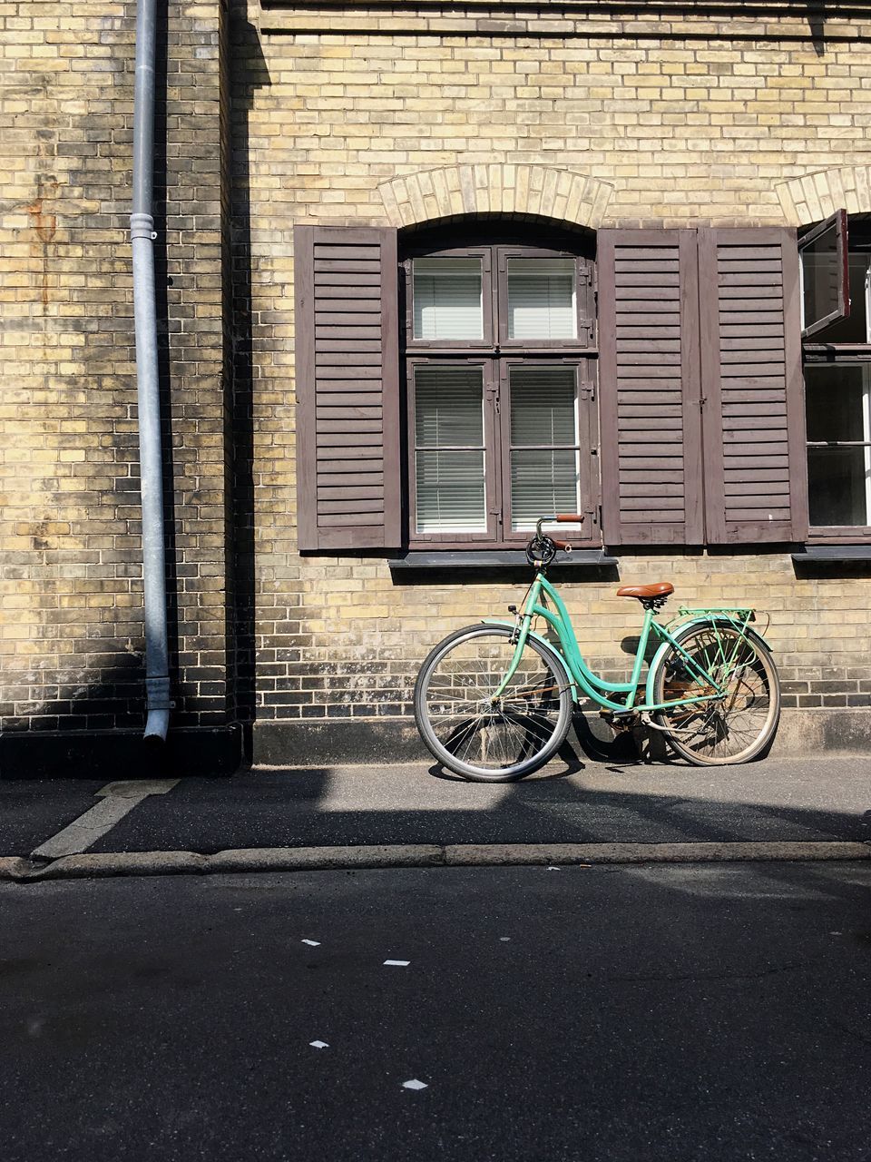 BICYCLE PARKED AGAINST BUILDING