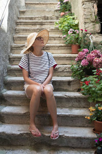 Full length of woman sitting on staircase