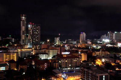 Illuminated buildings in city against sky at night