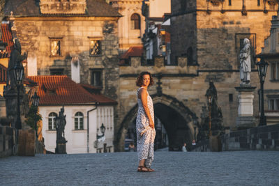 Woman walking through charles bridge, prague, czech republic