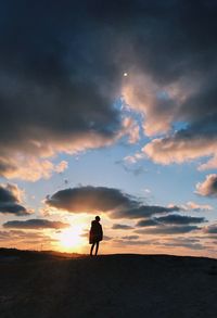 Silhouette man standing against sky during sunset