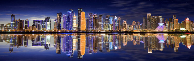 Panoramic view of illuminated urban skyline against sky