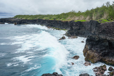 Scenic view of rocks on sea against sky