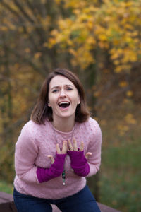 Portrait of woman standing against trees during autumn