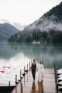 People on lake against sky