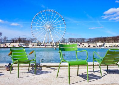 Ferris wheel in amusement park against blue sky