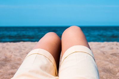 Low section of woman relaxing on beach