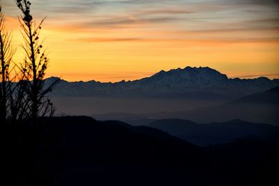 Scenic view of silhouette mountains against romantic sky at sunset