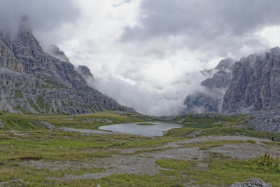 Scenic view of lake by mountains against sky