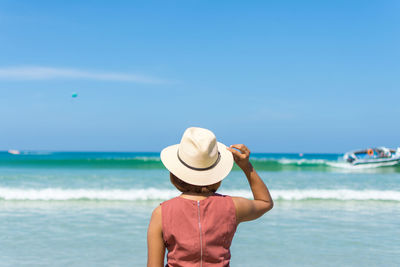 Rear view of man looking at sea against sky