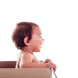 Cute boy looking away against white background