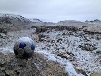 Rocks on field against sky during winter