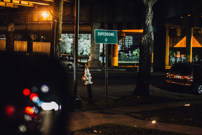 Cars on illuminated street in city at night