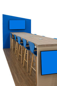 Empty chairs and tables against clear blue sky