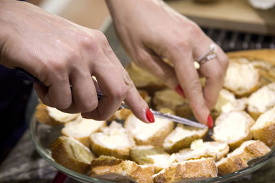 The girl prepares sandwiches from fresh bread with butter and red caviar