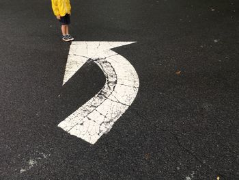 Low section of man standing on road