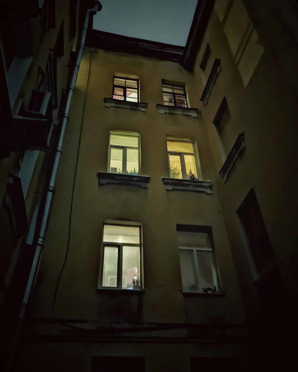 architecture, low angle view, illuminated, built structure, window, building exterior, building, no people, night, residential district, outdoors, lighting equipment, city, nature, wall, in a row, dark, reflection, apartment