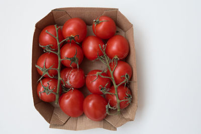 High angle view of tomatoes in basket on white background